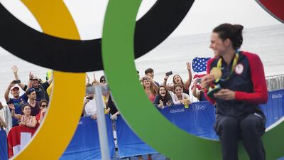 Spectators cheer for the United States’ Gwen Jorgensen as she poses with the gold medal in front of the Olympic rings after winning the women’s triathlon event on Copacabana beach at the 2016 Summer Olympics in Rio de Janeiro, Brazil, Saturday, August 20, 2016. David Goldman / AP Photo