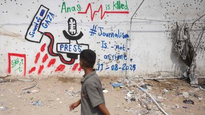 A Palestinian boy looks at graffiti on the wall at the site where a deadly Israeli strike destroyed an Al Jazeera tent and killed six journalists, at the Al-Shifa Hospital in Gaza city. AFP