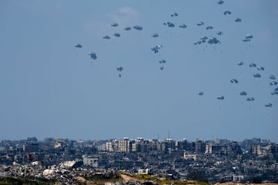 Parachutes carrying humanitarian aid dropped from an aircraft into Beit Hanoun, northern Gaza Strip, seen from southern Israel on Monday. AP