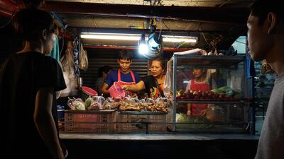 A family preparing food for customers at a street food stall in the Phrakanong district of Bangkok on April 17,2017. Street food stalls will be banned from all of Bangkok’s main roads under a clean-up crusade, a city hall official has announced. Lillian Suwanrumpha / AFP