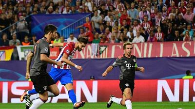 Atletico Madrid’s Yannick Carrasco, centre, kicks the ball to score past Bayern Munich’s Philipp Lahm. Pierre-Philippe Marcou / AFP