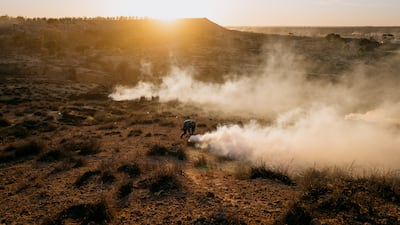 A protester runs from tear gas canisters fired by security forces across from the landfill. Photo: Erin Clare Brown / The National