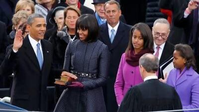 US Supreme Court chief justice John Roberts (back to camera) administers the oath of office to President Barack Obama as first lady Michelle Obama and daughters Malia and Sasha look on.