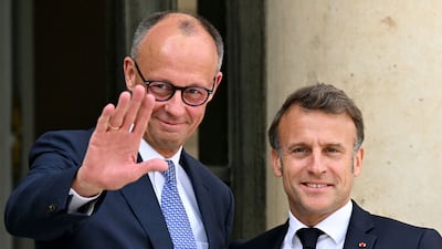 Germany's newly elected Chancellor Friedrich Merz, left, is welcomed by French President Emmanuel Macron at the Elysee presidential palace in Paris on May 7, 2025. AFP