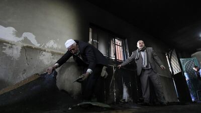 Palestinians inspect the damage to a mosque that was set alight in an attack in Jabaa village near the West Bank city of Bethlehem on February 25, 2015. Ammar Awad/Reuters