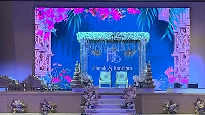 The mandap in the banquet hall was decked out with a canopy of green flowers, plus white and gold decor