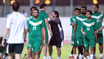 Coach Diego Maradona, in black shirt, jokes around with his Al Wasl players during a practice session in Dubai.