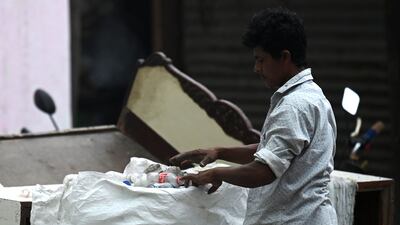 A man collects plastic bottles for recycling in New Delhi. AFP
