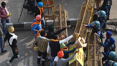 Farmers offer bananas and jaggery to the Indian security personnel at a road block stopping farmers from marching to New Delhi to protest against the central government's recent agricultural reforms. AFP