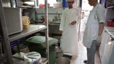 An inspector from the Abu Dhabi Food Control Authority carries out an inspection on a restaurant's kitchen facilities.