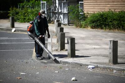 A worker cleans rubbish from the street at Angell Town estate in Brixton, London, Britain, June 25, 2020. REUTERS/Hannah McKay