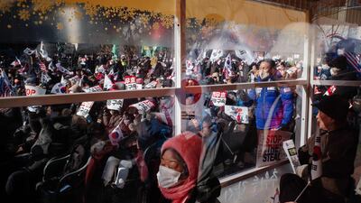 Supporters of impeached South Korean President Yoon Suk Yeol wave flags and shout slogans during a rally in Seoul. AFP