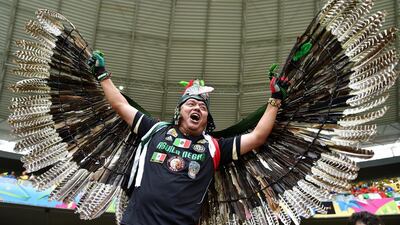 A Mexico fan poses with feathered wings before his team's match against Brazil on Tuesday at the 2014 World Cup in Fortaleza, Brazil. Buda Mendes / Getty Images