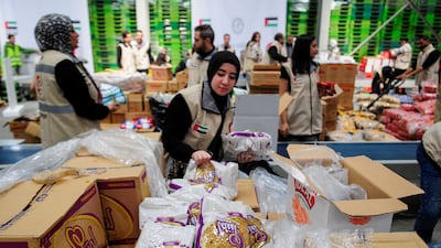 Volunteers from Emirates Red Crescent prepare parcels with humanitarian aid for Gaza. Reuters