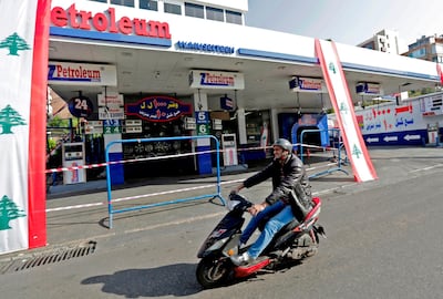 A man rides past a closed petrol station in Beirut as a dollar shortage forces Lebanon's fuel retailers to close in protest over higher costs. AFP