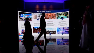Visitors pass in front of an advertisement screen at the 15th Regional Security Summit IISS Manama Dialogue 2019. REUTERS