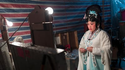 One Chiu Chow performer makes some final adjustments to her costume. EPA