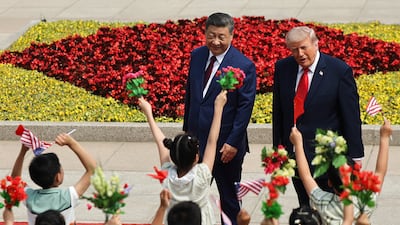 Children wave Chinese and American flags and flowers at the welcome ceremony at the Great Hall of the People. EPA
