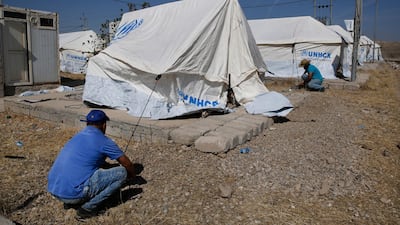 Workers set tents in preparation to receive a few hundred Syrian refugees who have been newly displaced by the Turkish military operation in northeastern Syria, at the Bardarash camp, north of Mosul, Iraq, Wednesday, Oct. 16, 2019. The camp used to host Iraqis displaced from Mosul during the fight against the Islamic State group and was closed two years ago. The U.N. says more around 160,000 Syrians have been displaced since the Turkish operation started last week, most of them internally in Syria. (AP Photo/Hussein Malla)