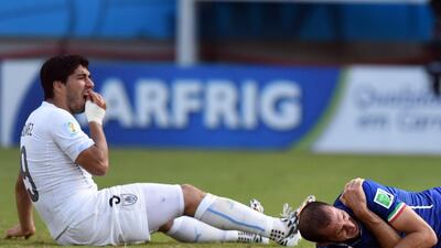 The moment that landed Luis Suarez a nine game international ban as the Uruguay striker, left, reacts after biting Italy defender Giorgio Chiellini. Javier Soriano / AFP
