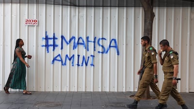 People walk by graffiti in support of the protests triggered by Amini's death, in Jerusalem. EPA