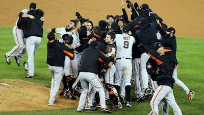 Sergio Romo is mobbed by San Francisco Giants teammates after striking out Miguel Cabrera to claim a decisive World Series victory against Detroit.