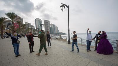 A bride and groom, right, take a selfie as Municipal policemen order them to evacuate the corniche, or waterfront promenade in Beirut. AP Photo