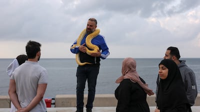 A man shows off his pet snake at the seafront in Beirut, as a 10-day ceasefire between Hezbollah and Israel is in place across Lebanon. Reuters