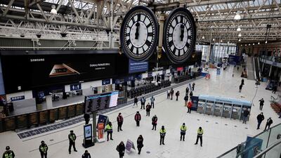 Commuters take part in a minute's silence on the first anniversary of the first national Covid-19 lockdown, at Waterloo Station in central London. AFP