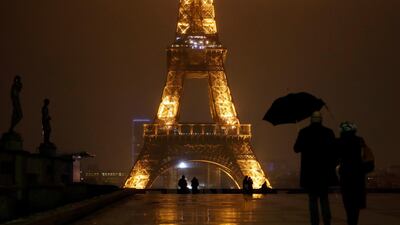 A couple walk on the Trocadero square near the Eiffel Tower during the curfew in Paris. All of France is under a stricter curfew, which started on Saturday at 6pm and will last for at least 15 days. AP Photo