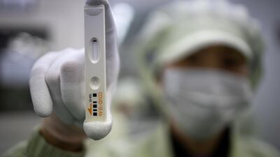 An employee holds up an Ichroma Covid-19 Ab testing kit at the Boditech Med headquarters in Chuncheon, South Korea. Bloomberg