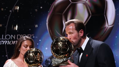 Spain and Barcelona midfielder Alexia Putellas and England and Bayern Munich forward Harry Kane kiss their Ballon d'Or trophies at the awards ceremony in London. AFP