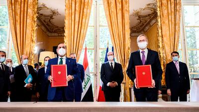 French Prime Minister Jean Castex and Iraqi Prime Minister Mustafa al-Kadhimi stand as CEO of Alstom Henri Poupart-Lafarge and Iraqi Transport Minister Nasser Hussain Al-Bandar pose during a contracts and economic agreements signing ceremony at the Hotel de Matignon in Paris, after a meeting between the French and Iraqi prime ministers. AFP