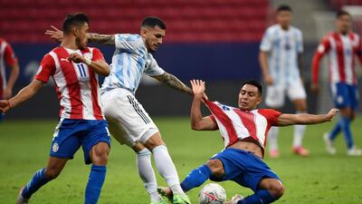 Paraguay's Angel Romero (L) and Alejandro Romero challenge Leandro Paredes (C) for the ball. AFP
