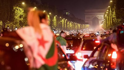 Algeria's supporters react to their success with the Algerian national flag in front of the Arc de Triomphe. AFP