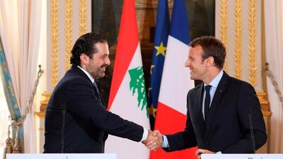 This file photo taken on September 1, 2017 shows French President Emmanuel Macron (R) shaking hands with Lebanese Prime Minister Saad Hariri during a press conference at the Murat Lounge in the Elysee Palace in Paris. AFP / Ludovic Marin