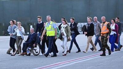 Mr Vandecasteele's relatives approach the plane to meet him. Reuters