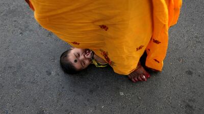 A woman steps over an infant in a ritual seeking blessings for the infant from the Sun god in Kolkata. Reuters
