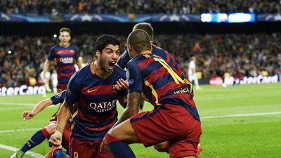 Luis Suarez celebrates with teammates after striking late to seal a narrow win over Bayer Leverkusen. LLuis Gene / AFP