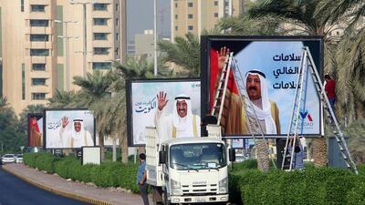 Workers fix large portraits of the emir of Kuwait, Sheikh Sabah al-Ahmad al-Jaber al-Sabah, on one of the main roads in Kuwait City on October 16, 2019, to mark his return to the country after a medical trip in the USA. The ruler of Kuwait has been admitted to a hospital in the United States for "medical tests" last month, according to senior officials in the Gulf emirate. The sources did not specify the type of tests the 90-year-old emir was undertaking. / AFP / Yasser Al-Zayyat