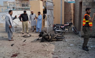 Pakistani security officials examine the site of a bombing on an entrance of a hospital in Dera Ismail Khan. AP