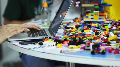 Attendees use laptop computers as Lego toybricks sit on a desk in the Hackathon area at the Bosch Internet of Things (IoT) conference, in Berlin. Bloomberg