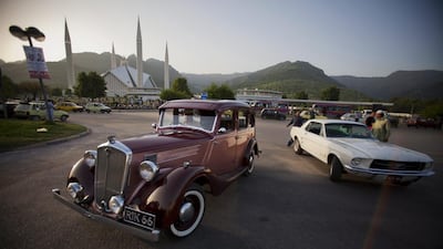 Pakistani businessman Raja Mujahid Zafar, left, drives his Wolseley.