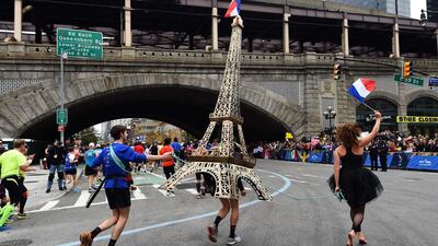 A runner carries a model of the Eiffel Tower during the New York Marathon. Jewel Samad / AFP Photo