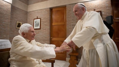 Pope Francis greets Pope Emeritus Benedict XVI during a meeting following a consistory ceremony to install 13 new cardinals, at the Vatican, November 28, 2020. Vatican Media/Handout via Reuters