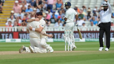 The umpire declares India captain Virat Kohli, centre, dismissed, as England's James Anderson, second left, hugs teammate Ben Stokes. AP Photo