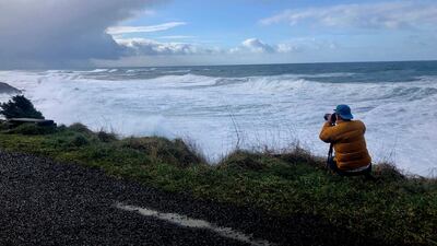 A man photographs waves crashing onto the cliffs at Rodea Point in Lincoln County, Oregopn during an extreme high tide that coincided with a big winter storm. AP Photo/Gillian Flaccus