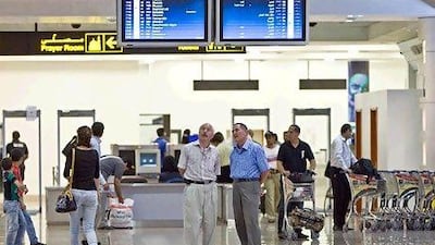 Passengers check their flight schedules at Dubai International Airport Terminal 2 in Dubai. Amy Leang/The National
