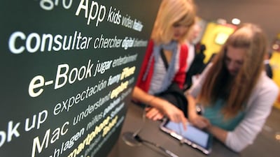 Visitors try out mobile devices to read books during Frankfurt Book Fair in western Germany. Daniel Roland / AFP