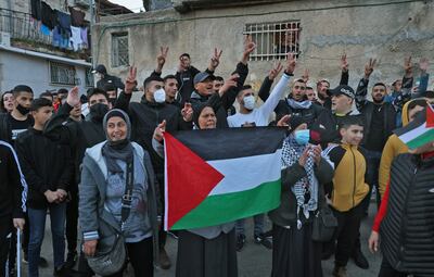 A woman waves a Palestinian flag during a protest in the flashpoint neighbourhood of Sheikh Jarrah in Israeli-occupied east Jerusalem. AFP